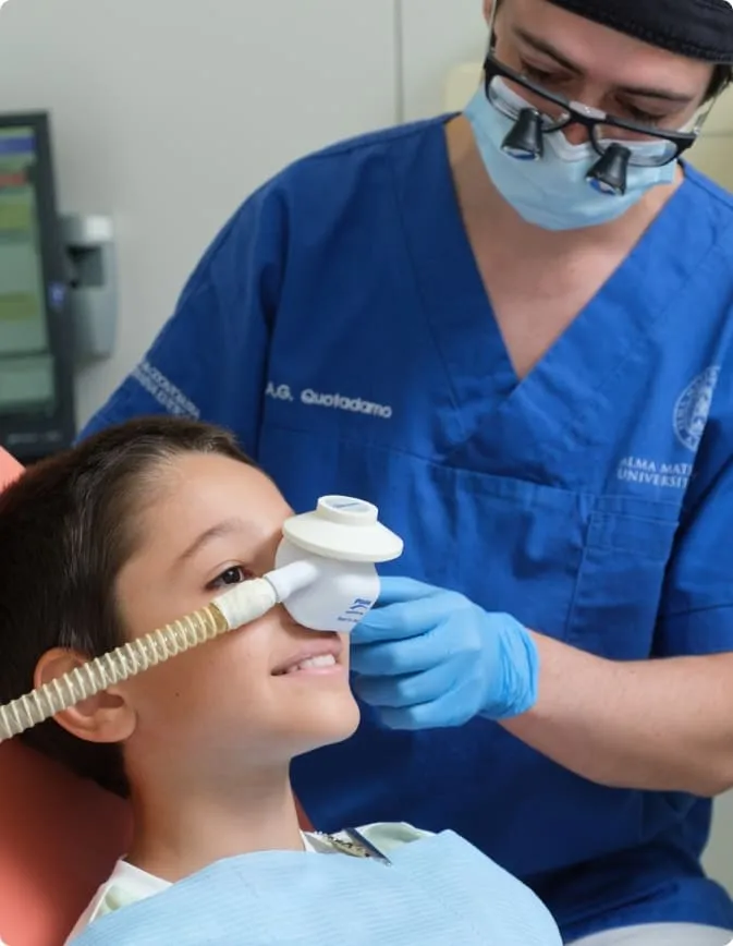 Un bambino respira la miscela della sedazione cosciente dalla mascherina sul naso