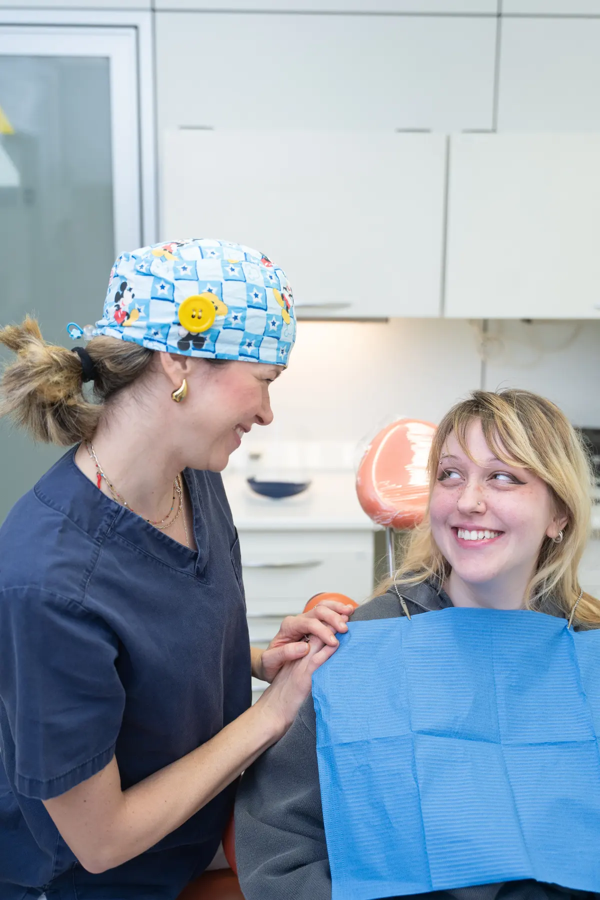 Una giovane paziente sorride insieme a una professionista dello Studio Dentistico Vittorio Ferri